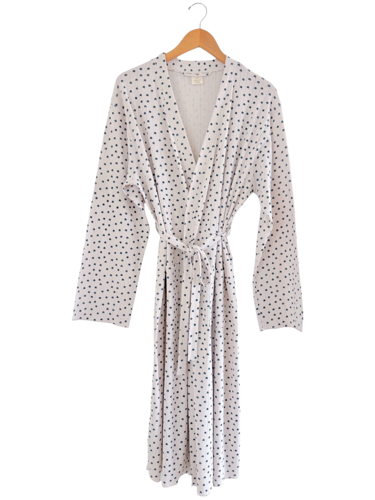 Lightweight polka dot robe on a hanger, featuring long sleeves and a tied waist. Ideal for comfort and style.