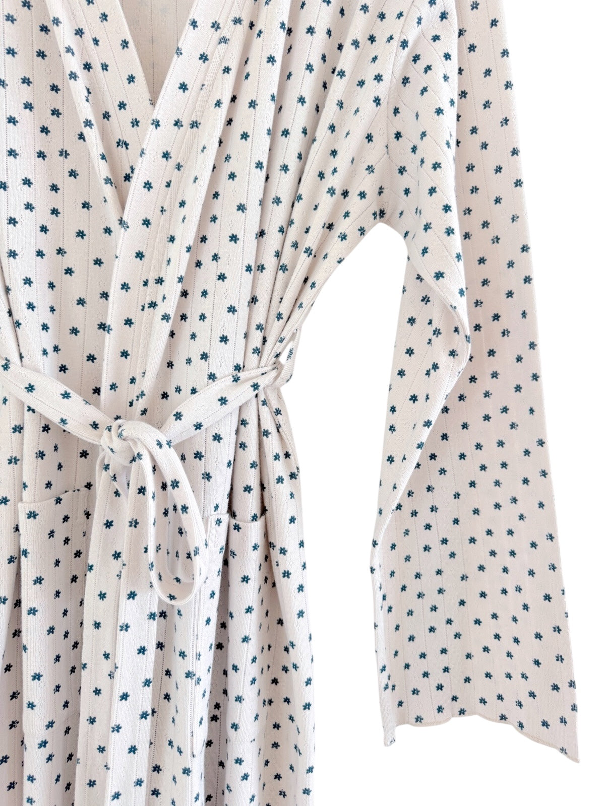 White robe featuring a blue floral pattern and a tied waist, showcased against a neutral background.