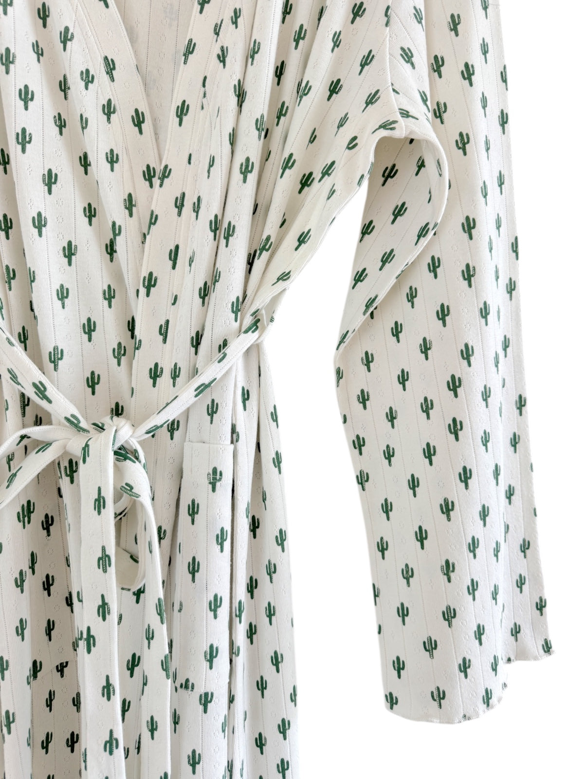 White robe with green cactus patterns, featuring a tied waist and long sleeves.