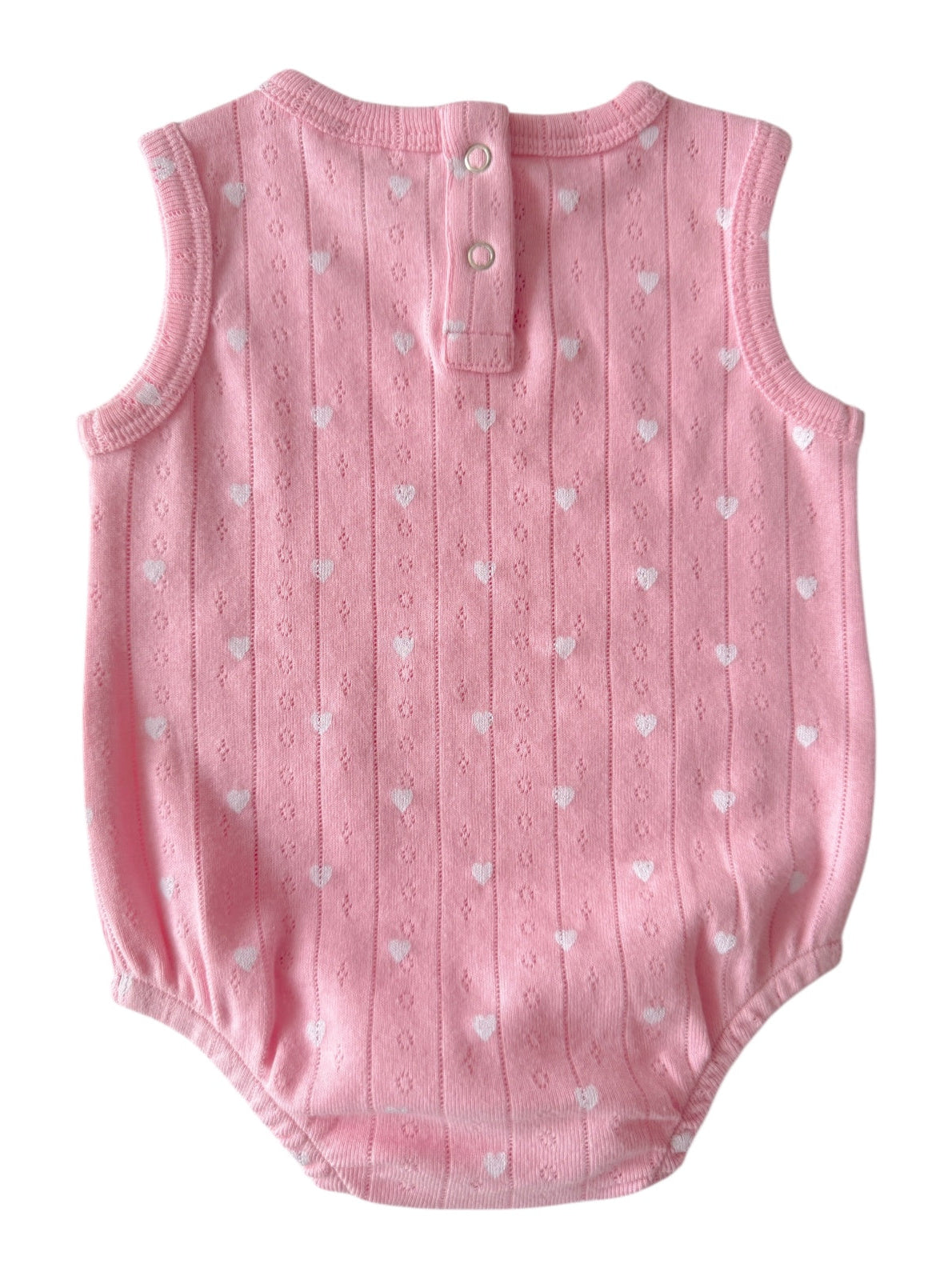 Pink sleeveless baby romper with white heart patterns and button closure at the back.