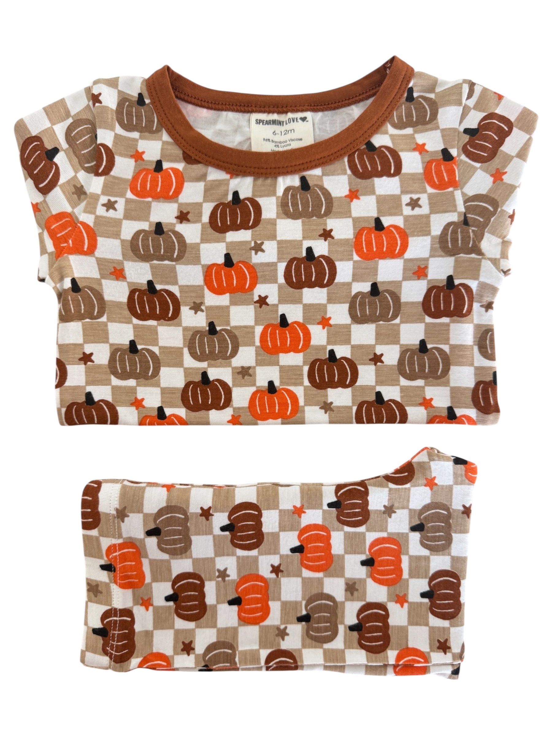 Brown and orange pumpkin-patterned toddler pajamas laid flat, featuring short sleeves and a comfy waistband.