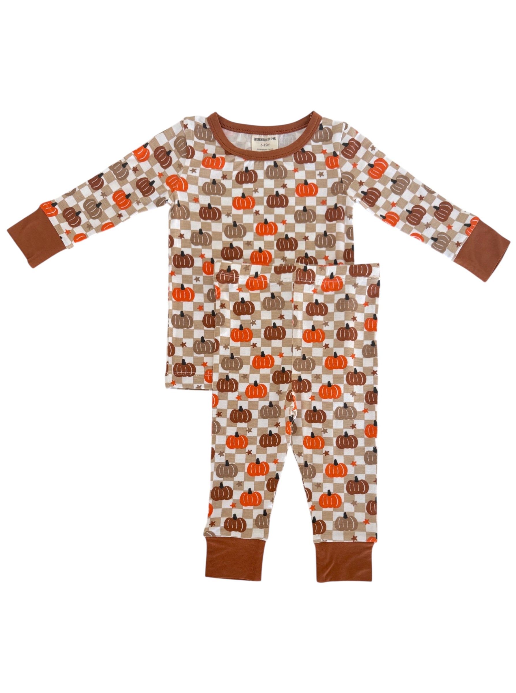 Kids' pajamas with pumpkin print in warm colors, featuring long sleeves and elastic waistband pants.