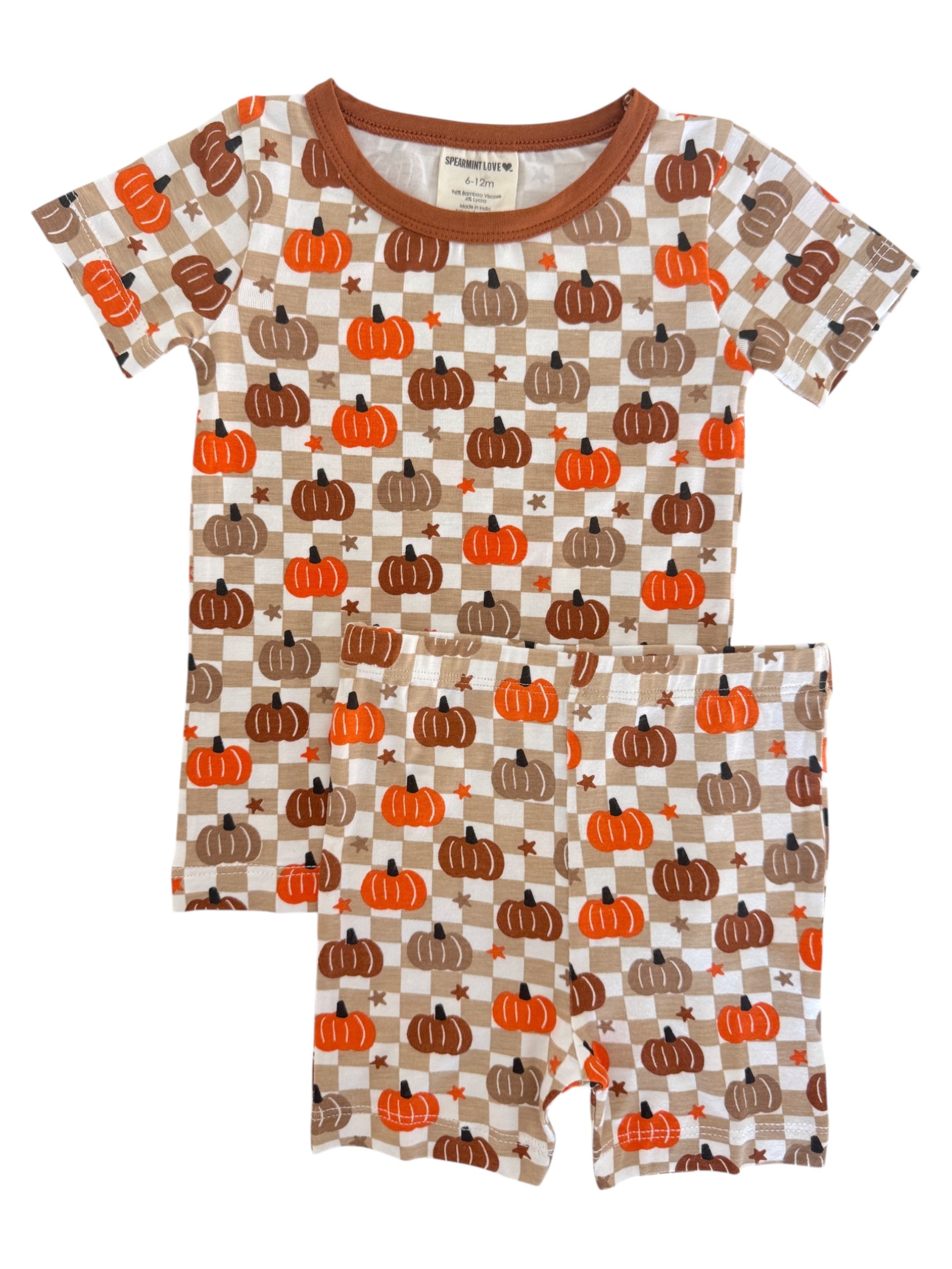 Children's pajama set featuring a pumpkin and checkerboard pattern in orange, brown, and cream colors.