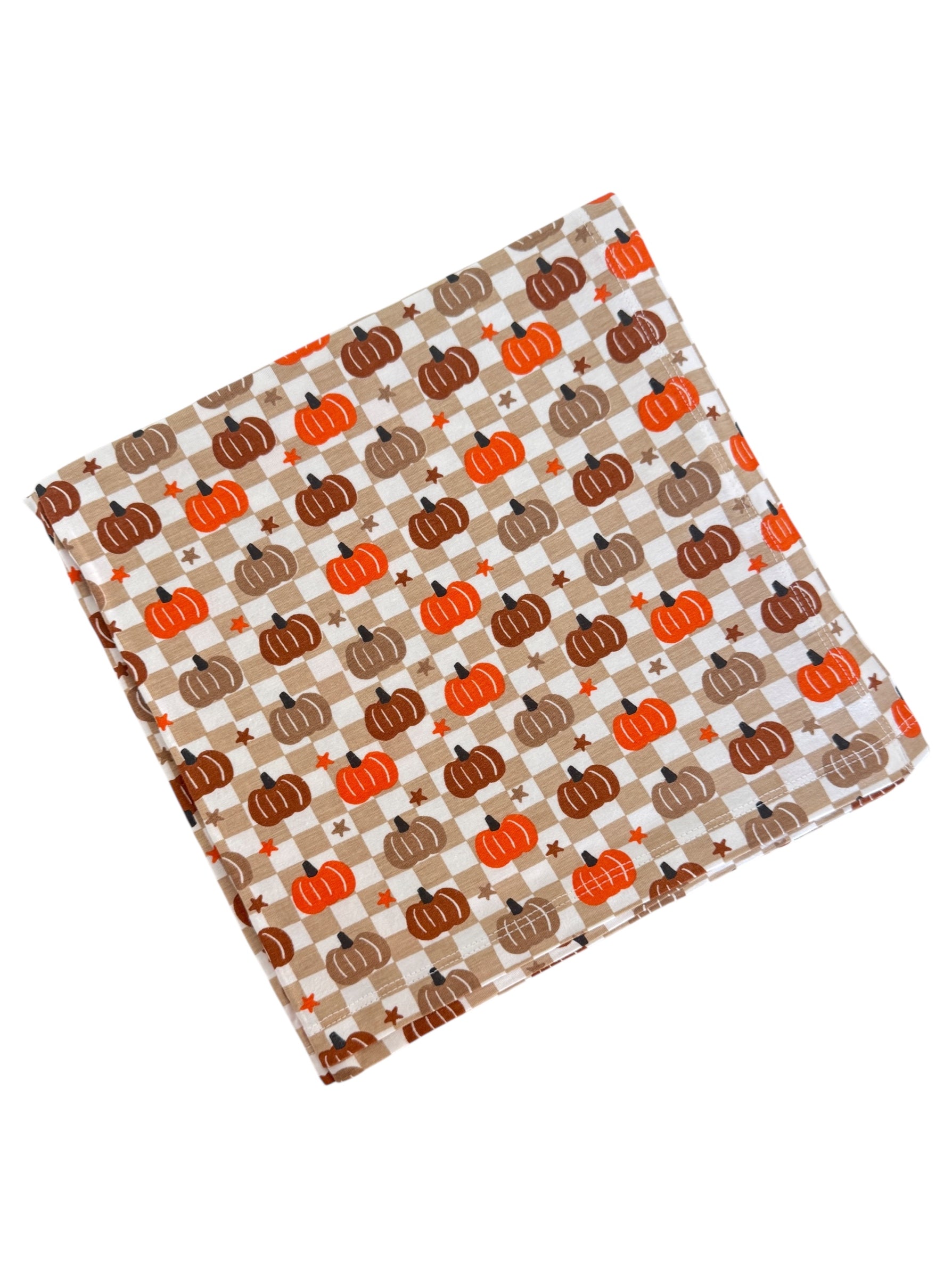 Fabric square with an orange and brown pumpkin pattern on a checkered background. Ideal for fall décor or crafts.