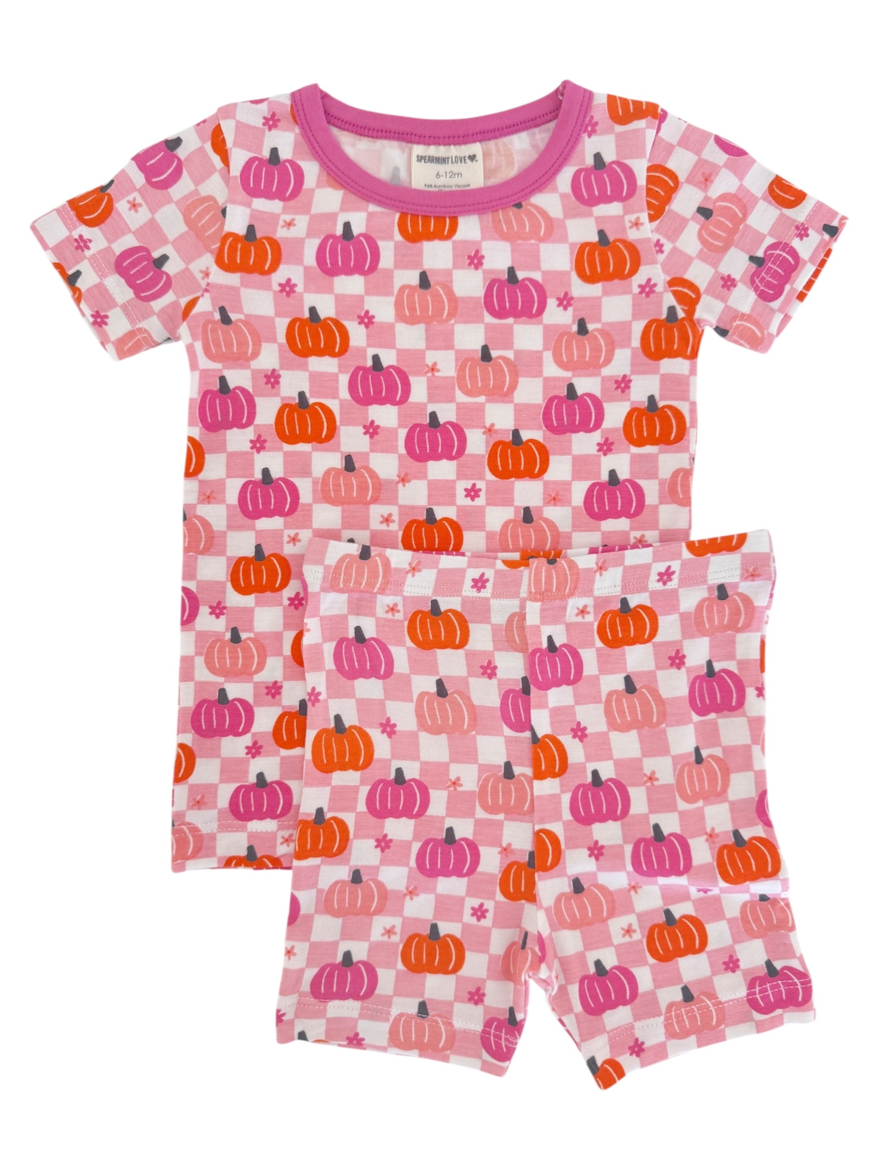 Pink children's pajamas with pumpkin patterns, featuring a short-sleeve top and matching shorts.