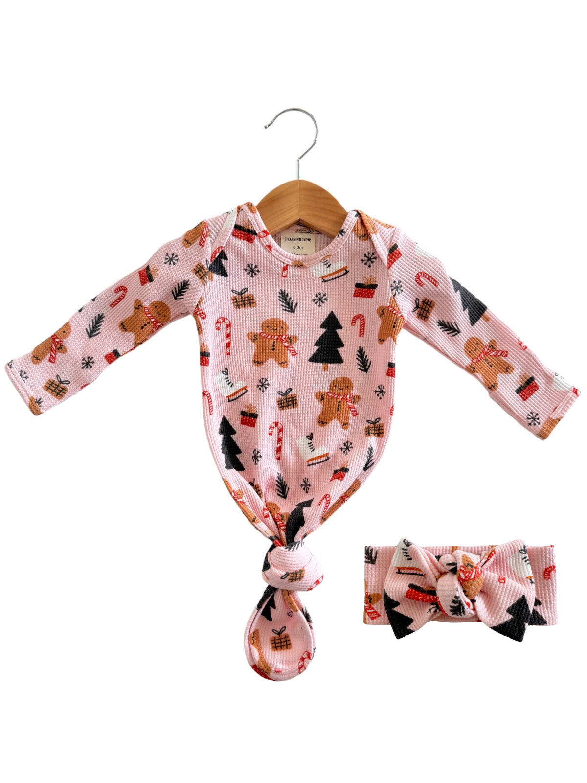 Pink baby onesie with gingerbread and candy cane print, paired with a matching headband. Perfect for holidays!