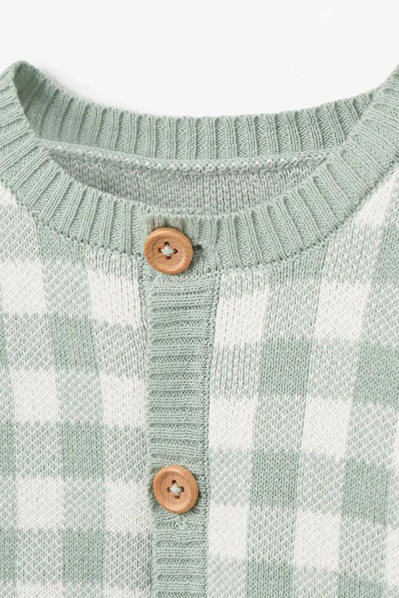 Green and white checkered sweater with a round neckline and wooden buttons.