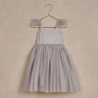 Gray dress with feathered straps and a twirl-ready skirt, hanging on a rose gold hanger against a soft background.