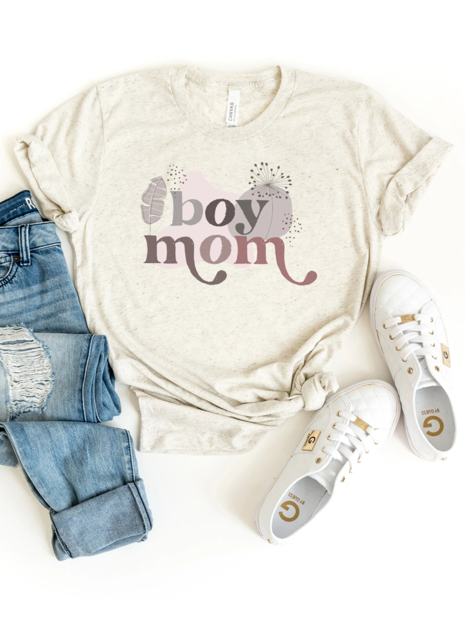 Light heathered tee with "boy mom" graphic, paired with casual jeans and white sneakers, on a white background.