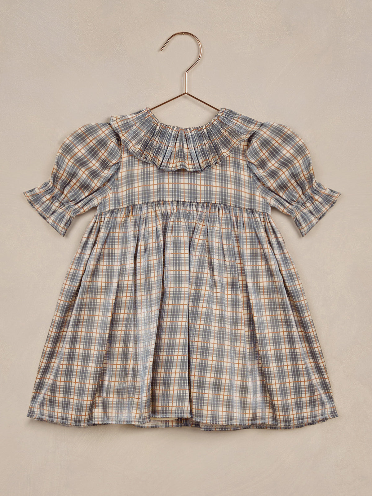 Blue and orange plaid dress with puff sleeves and a ruffled collar, suspended on a hanger.