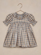 Blue and orange plaid dress with puff sleeves and a ruffled collar, suspended on a hanger.