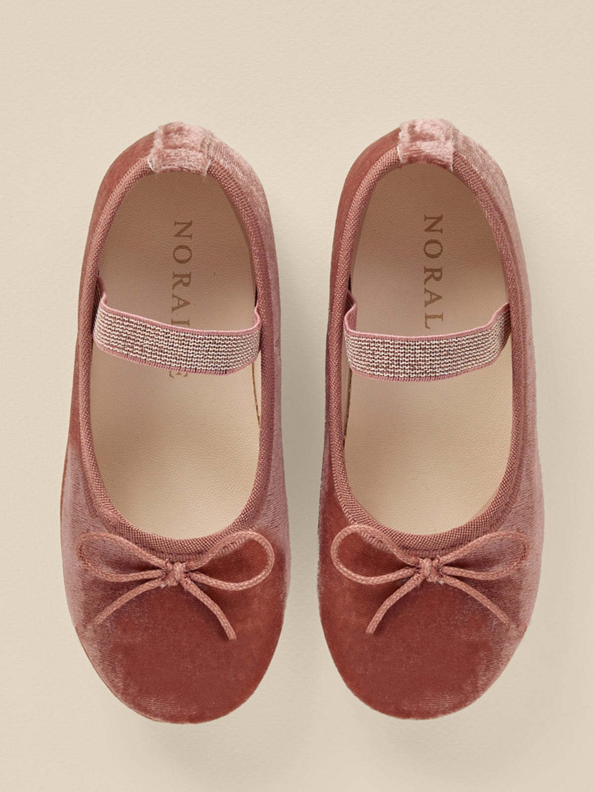 Pink velvet ballet flats with a bow and a sparkly strap, viewed from above. Ideal for stylish comfort.