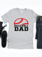 Gray t-shirt with "BASEBALL DAD" text and baseball graphic, paired with jeans and black sneakers.