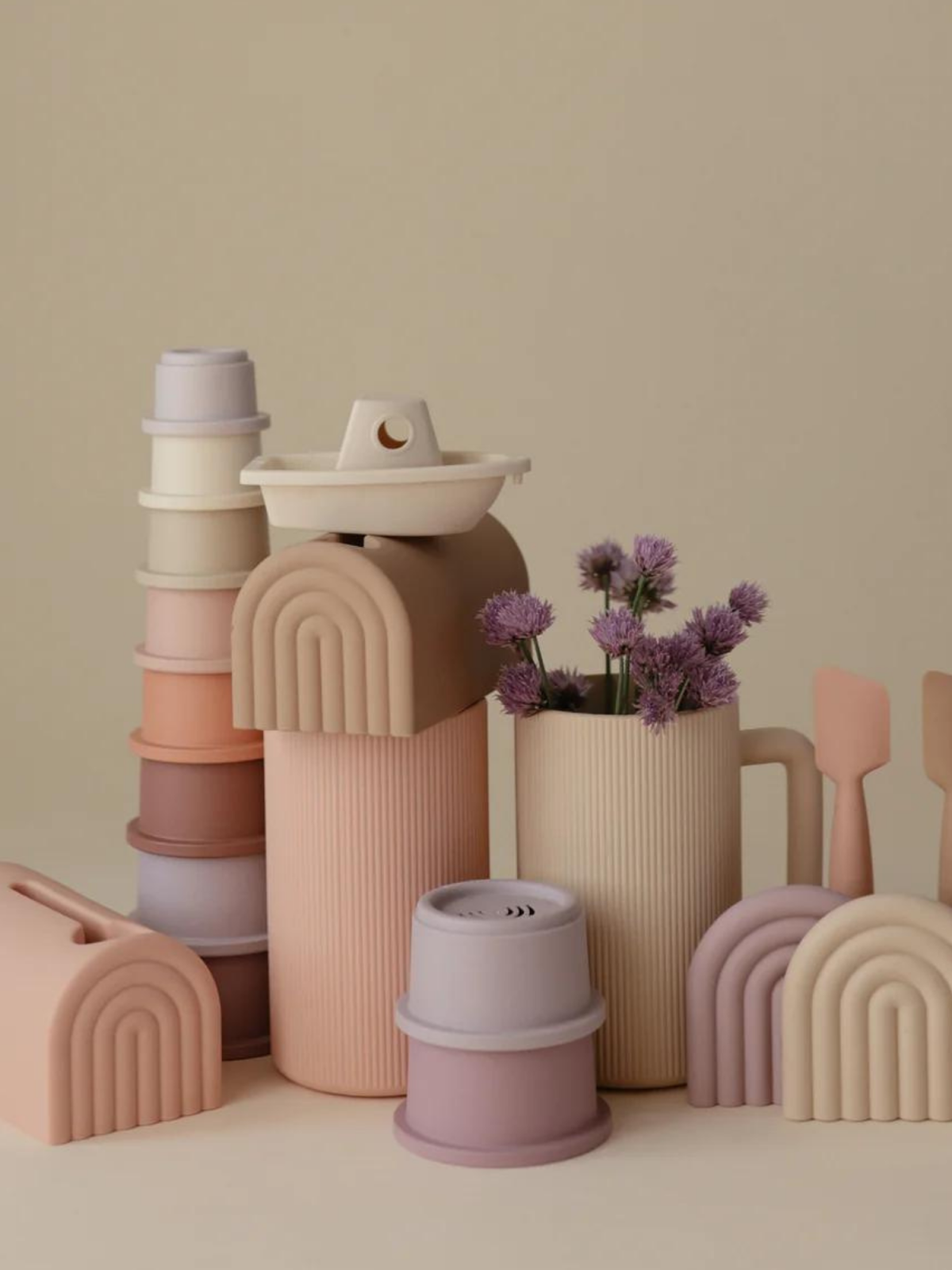Pastel-colored kitchen items with flowers, featuring various shaped containers and utensils against a neutral background.
