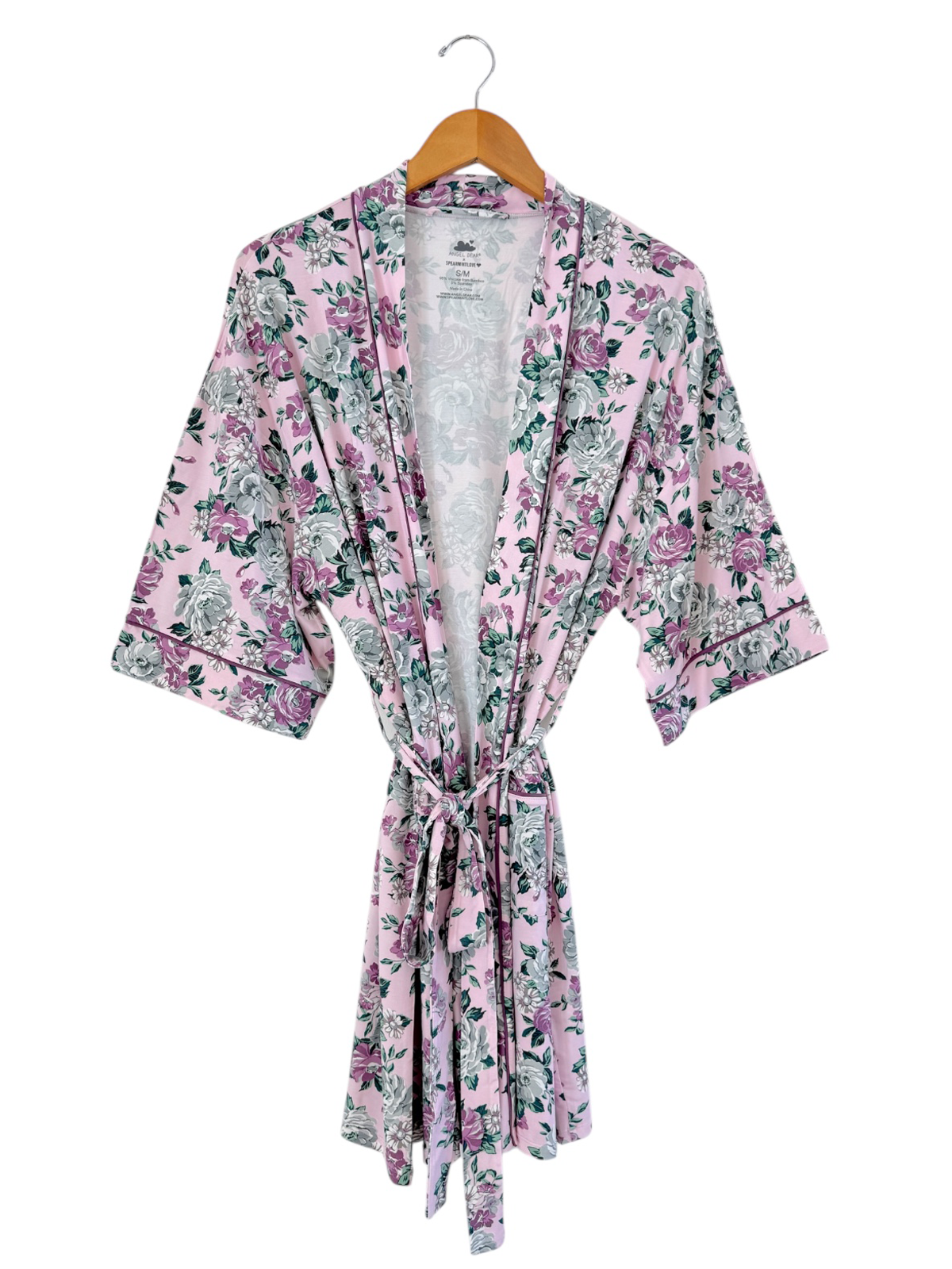 Floral print pink robe hanging on a wooden hanger against a white background.