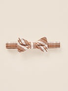 Brown and white striped bow tie on a light background. Perfect accessory for formal attire.