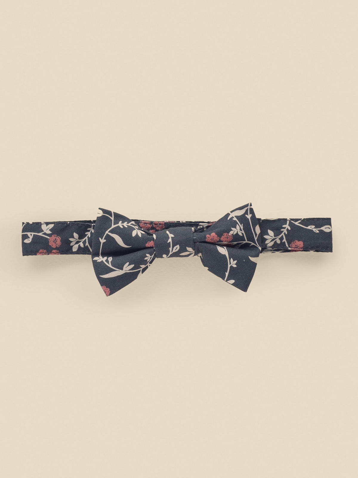Floral patterned navy bow tie on a light background, featuring small roses and greenery designs.