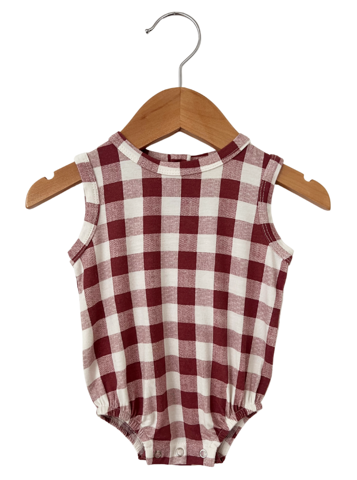 Red and white checkered baby onesie hanging on a wooden hanger.