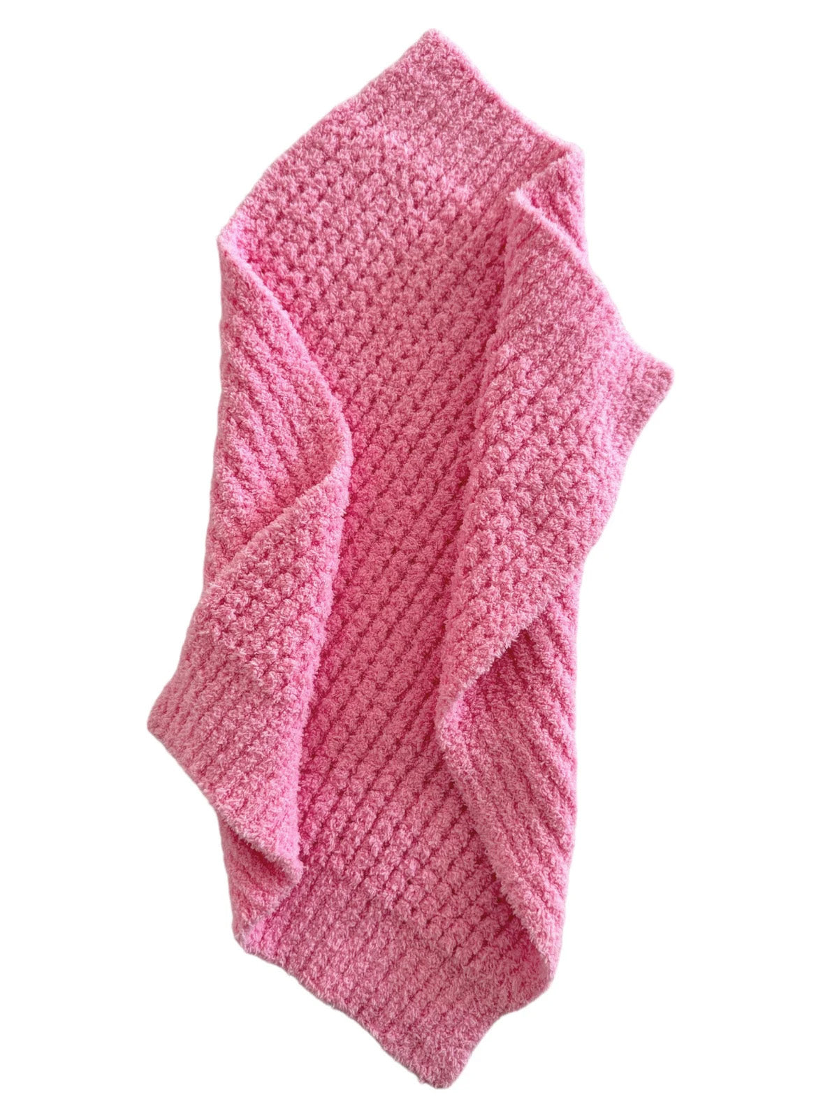 Soft, textured pink blanket draped casually, showcasing its cozy and inviting appearance.