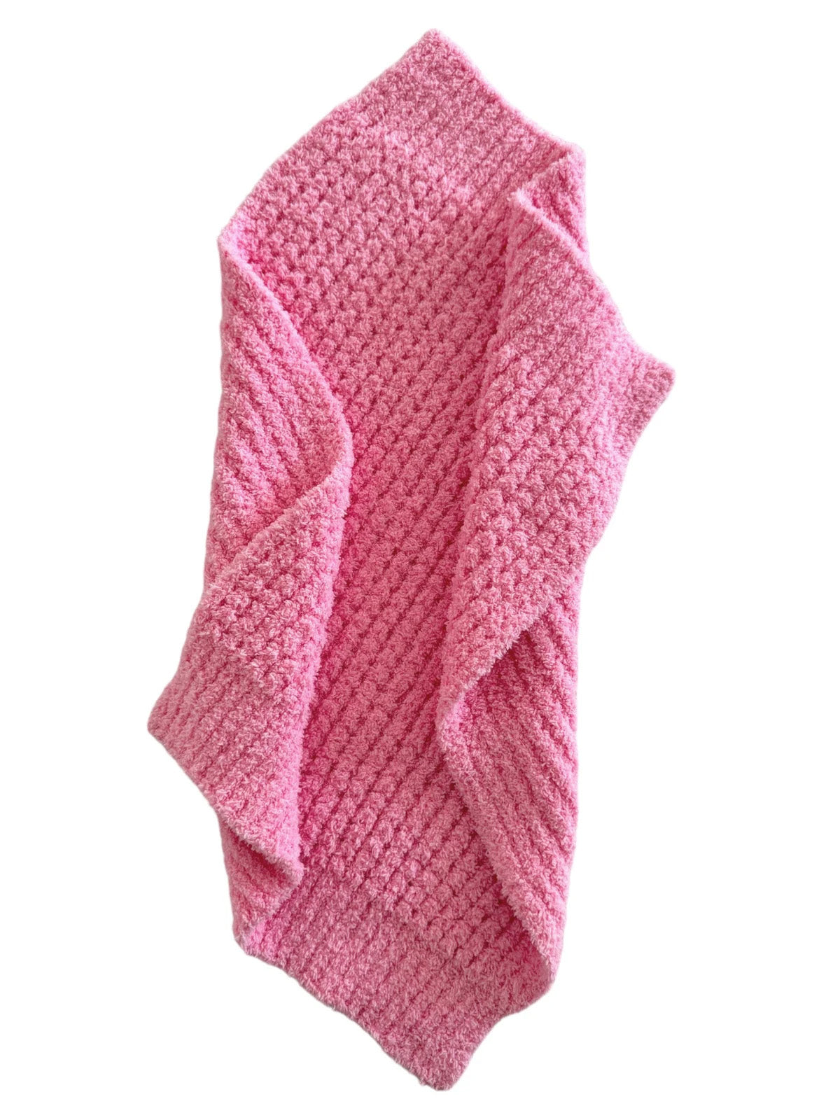 Soft, textured pink blanket draped casually, showcasing its cozy and inviting appearance.