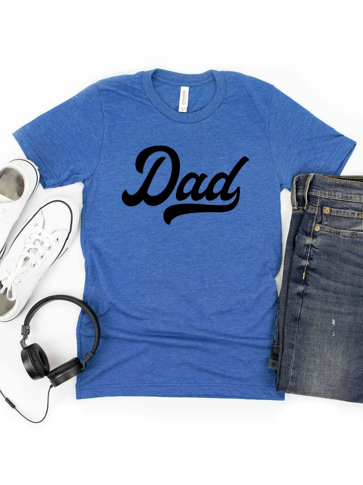 Blue t-shirt with "Dad" printed in black, paired with white sneakers, headphones, and denim shorts.