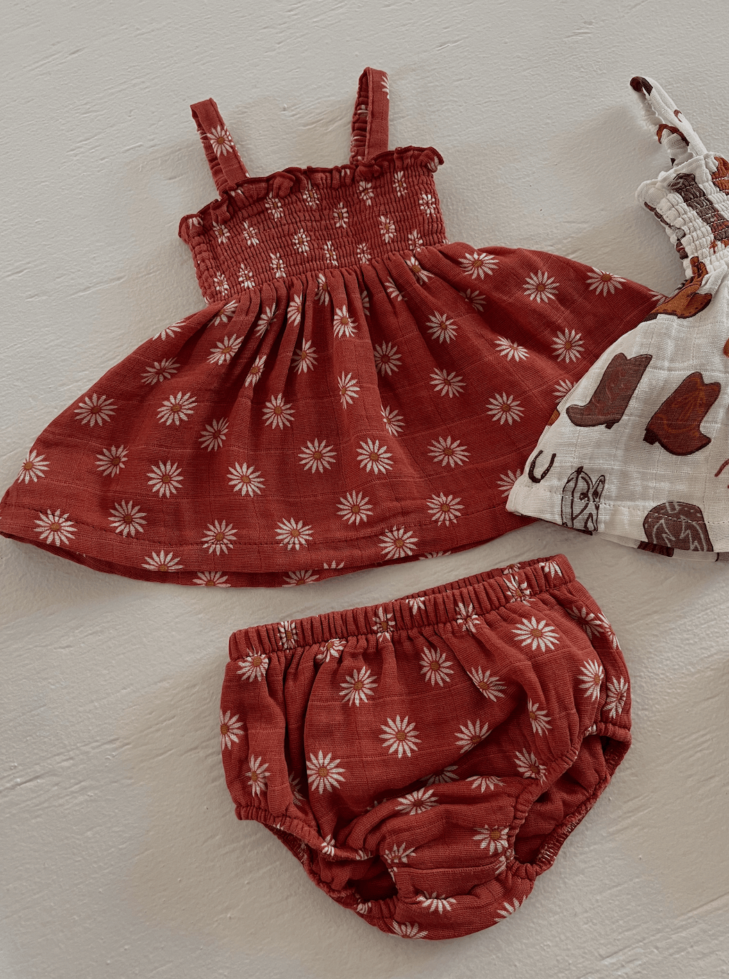 Red floral baby dress and matching bloomers on a light background.