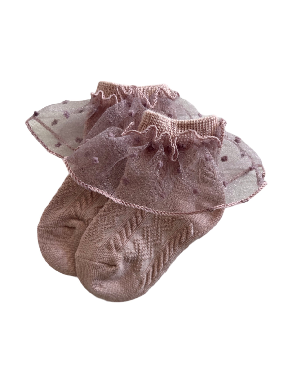 Pink baby socks with a frilly, sheer overlay and polka dots, showcasing a stylish and delicate design.