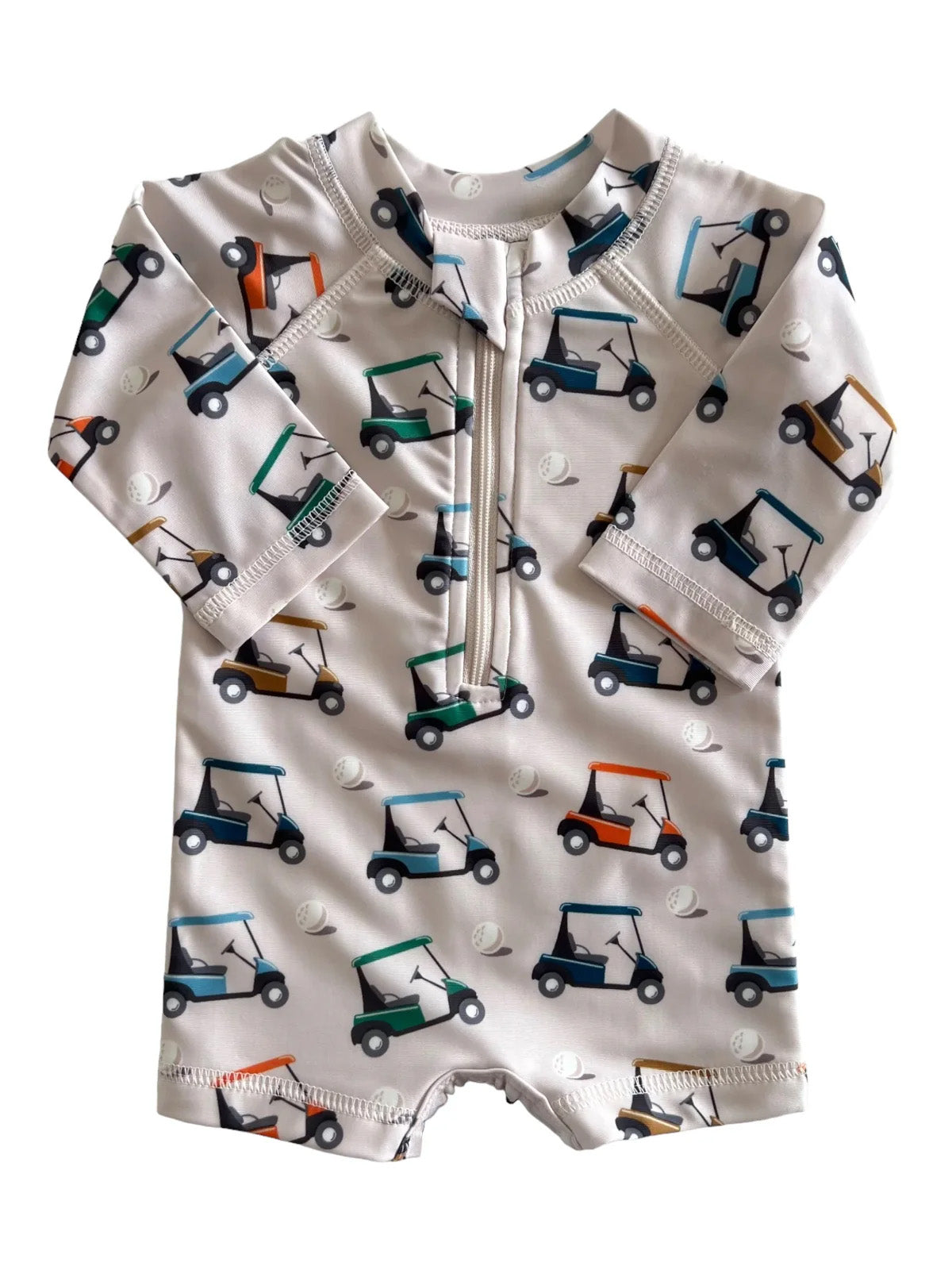 Kids' golf-themed rash guard with a zipper, featuring colorful golf carts on a light background.