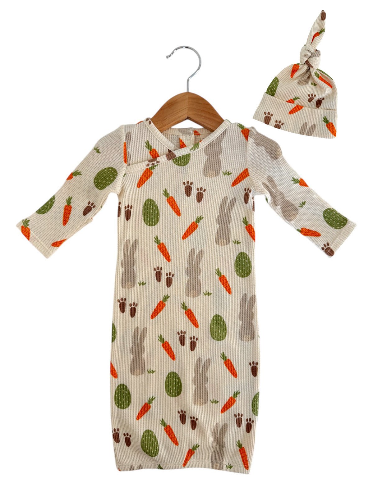 Baby outfit featuring a ribbed gown with bunny, carrot, and egg patterns, paired with a matching knot hat.