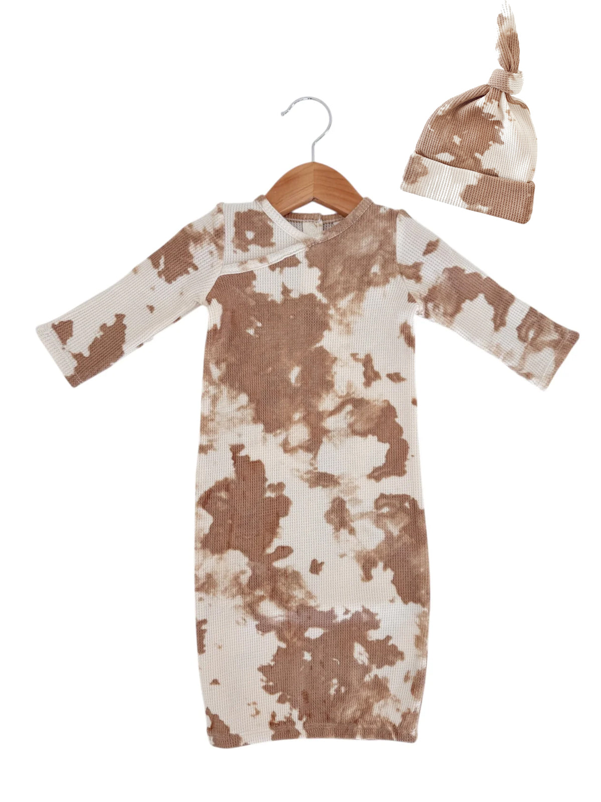 Brown and cream tie-dye dress and matching hat hung on a wooden hanger.