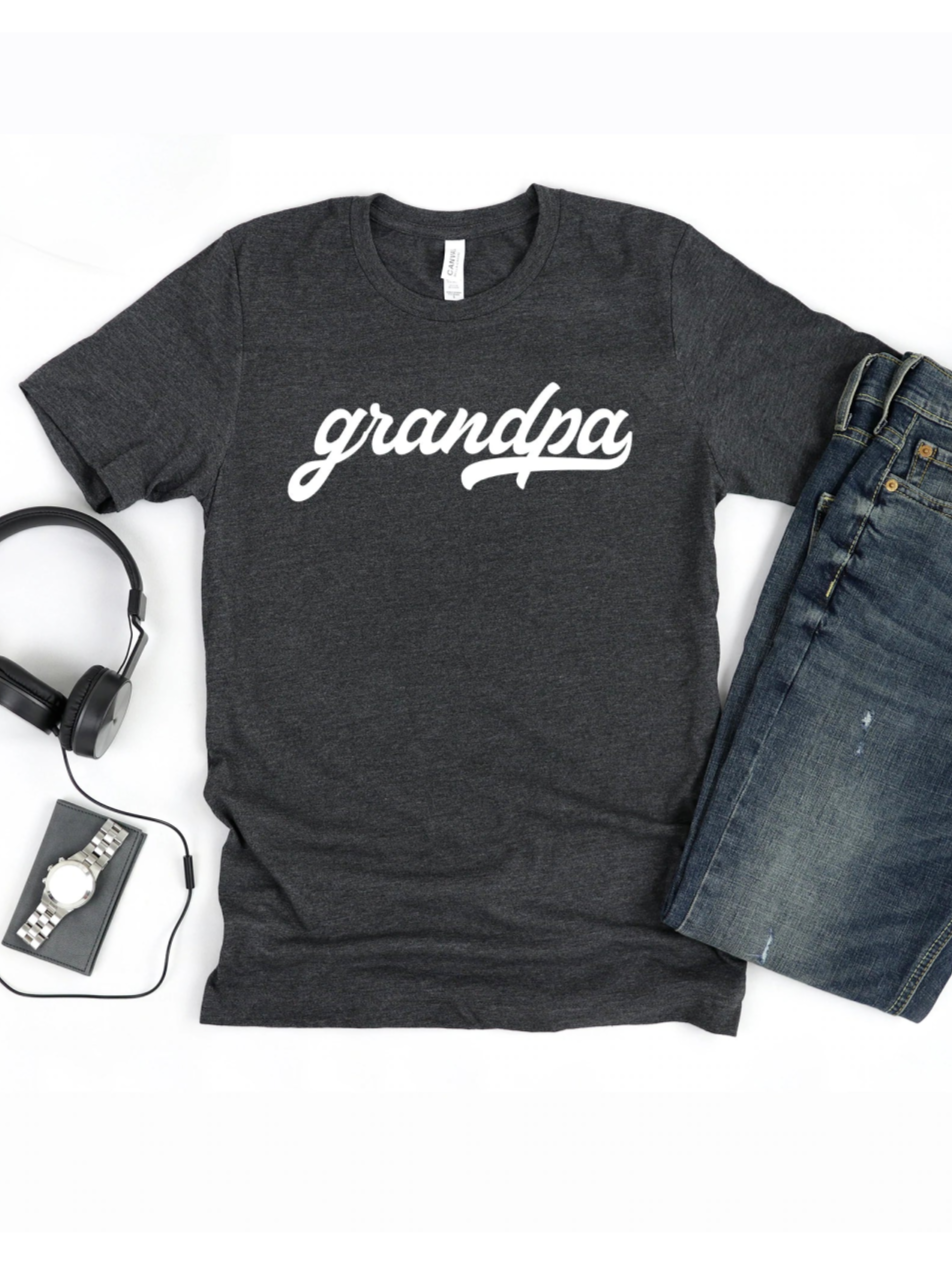 Gray t-shirt with "grandpa" printed in white, paired with jeans, headphones, watch, and wallet.