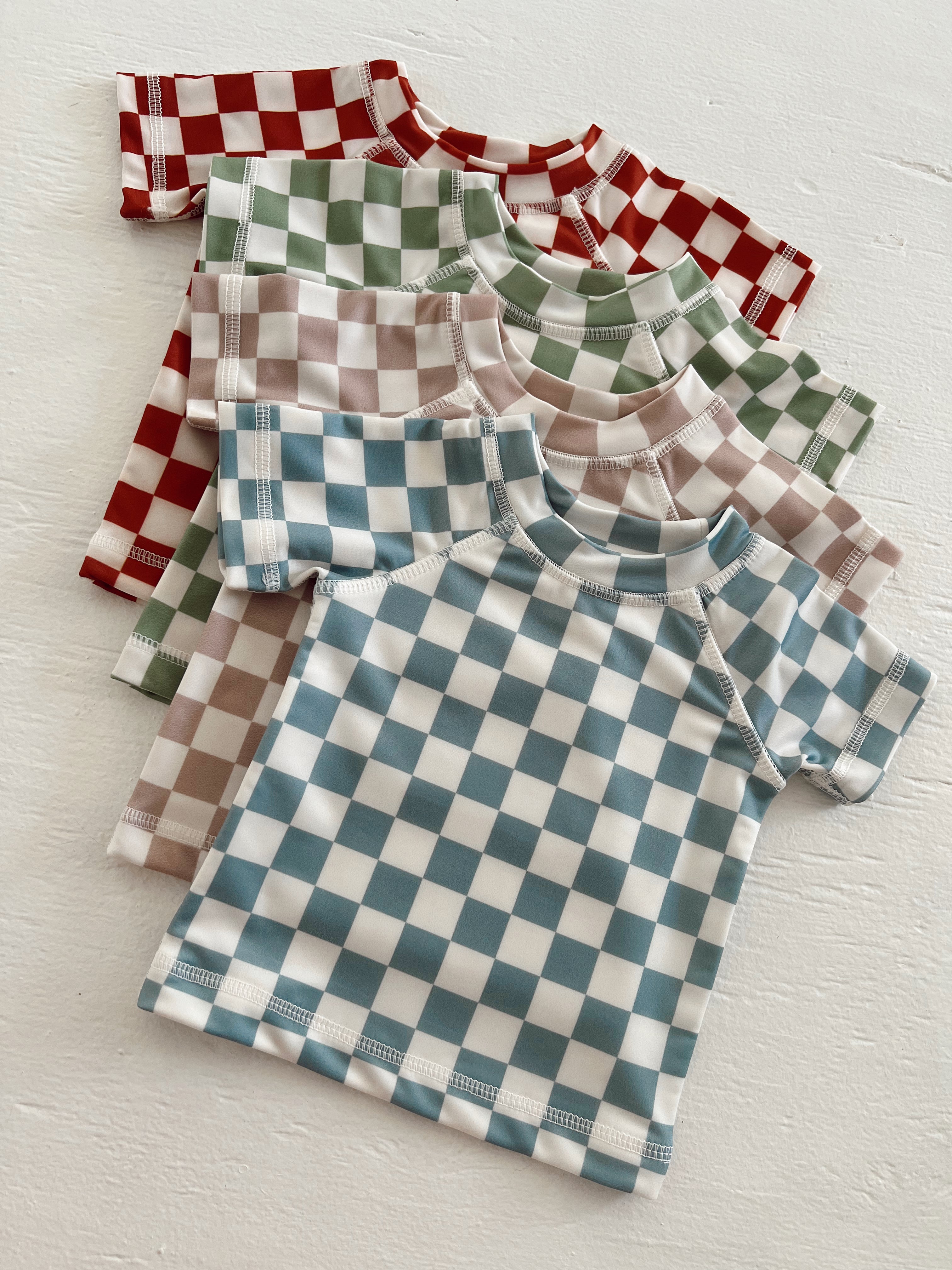 Collection of checkered short-sleeve shirts in red, green, beige, and blue on a white background.