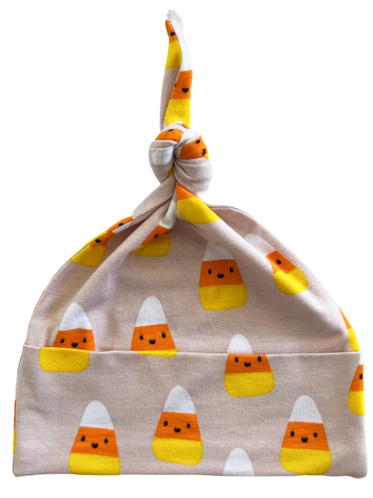Knotted baby hat featuring playful candy corn patterns in orange, yellow, and white on a soft pink background.