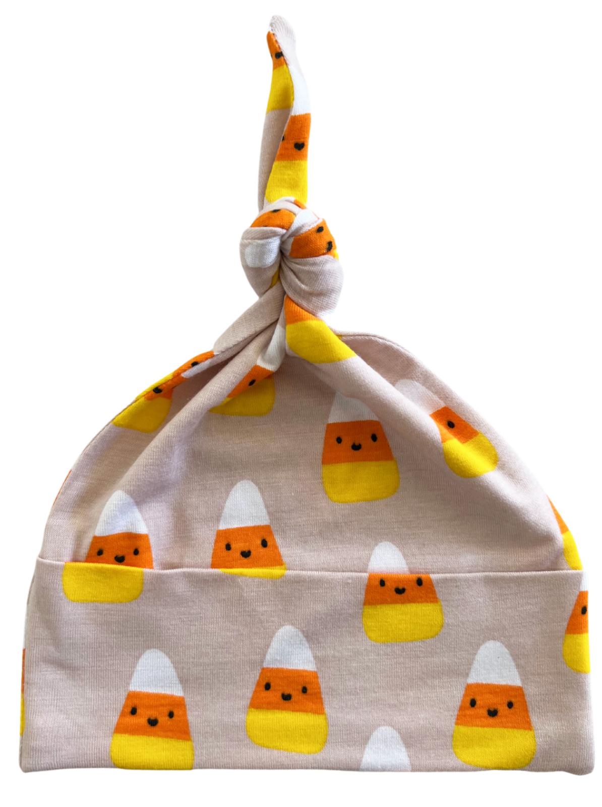 Knotted baby hat featuring playful candy corn patterns in orange, yellow, and white on a soft pink background.