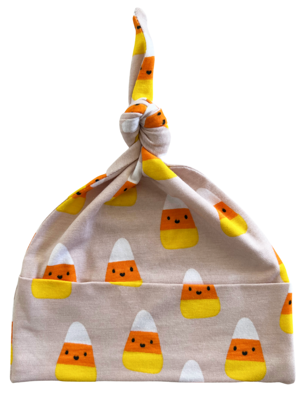 Knotted baby hat featuring playful candy corn patterns in orange, yellow, and white on a soft pink background.