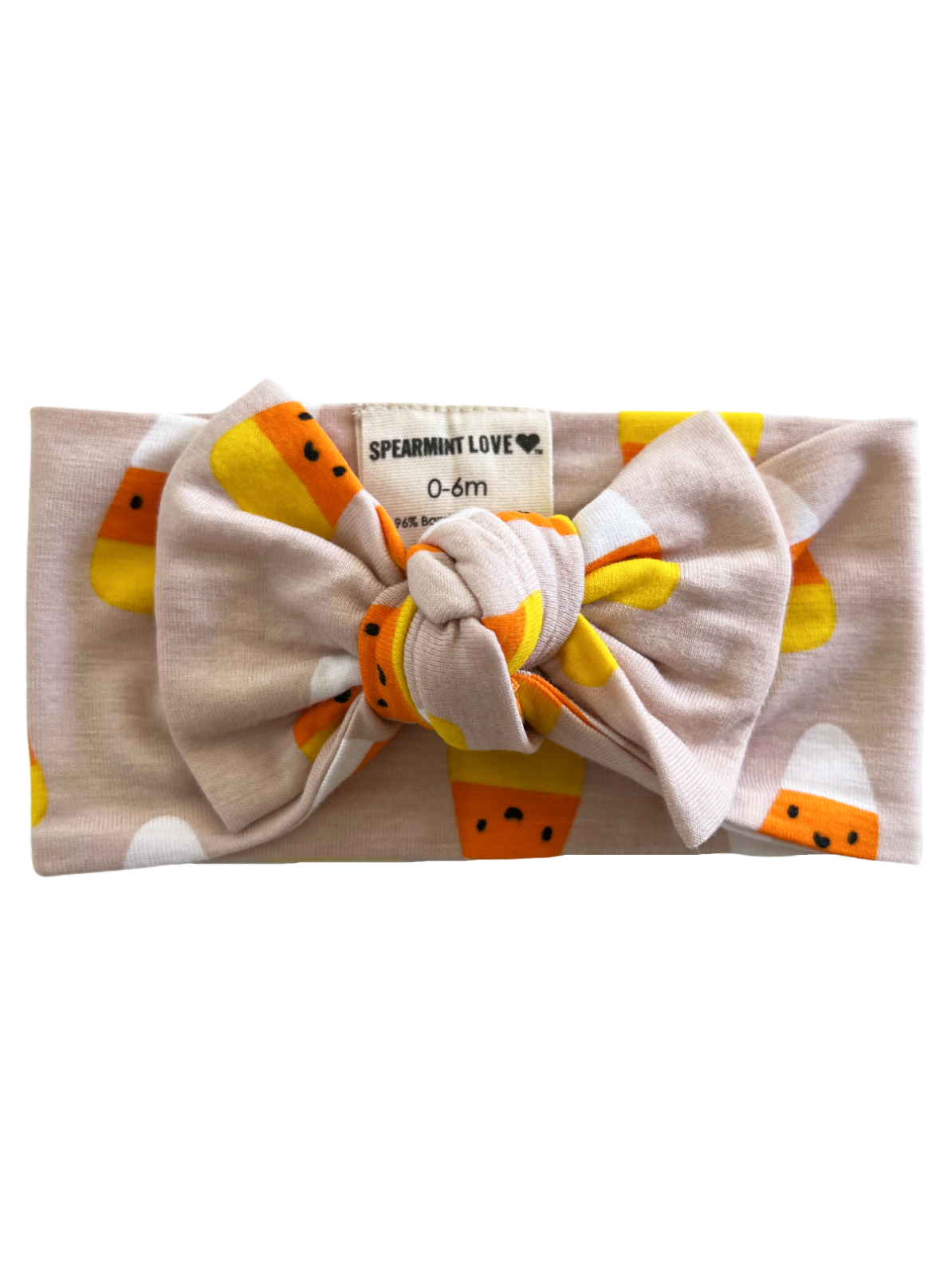 Light pink baby headband with a large bow and candy corn pattern, labeled for ages 0-6 months.