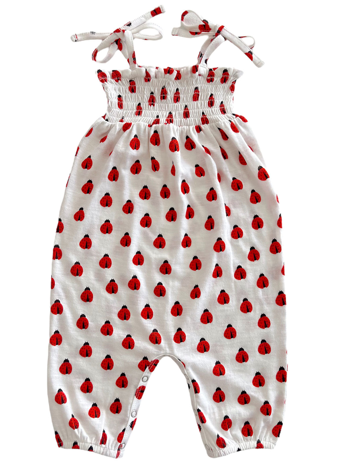 White romper with red ladybug pattern and adjustable tie straps. Ideal for infants and toddlers.