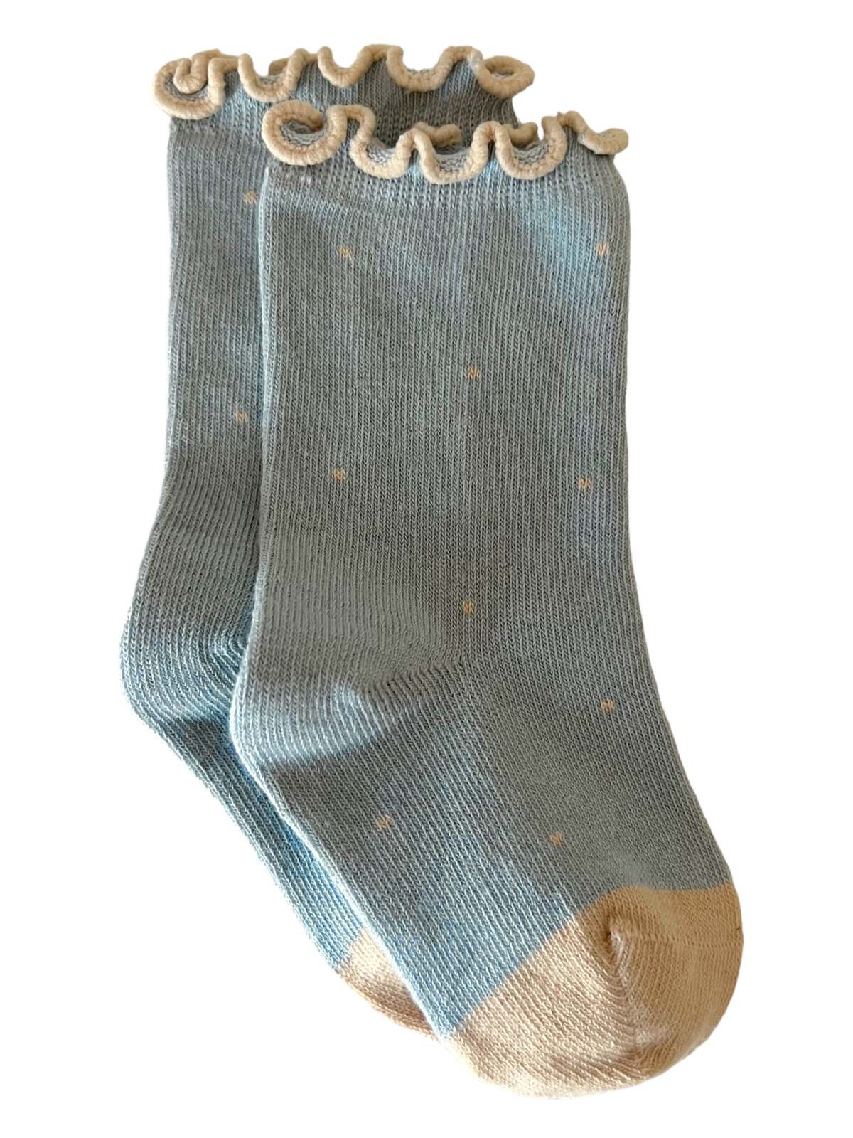 Light blue ankle socks with a ruffled top and beige toe, featuring small dots throughout.