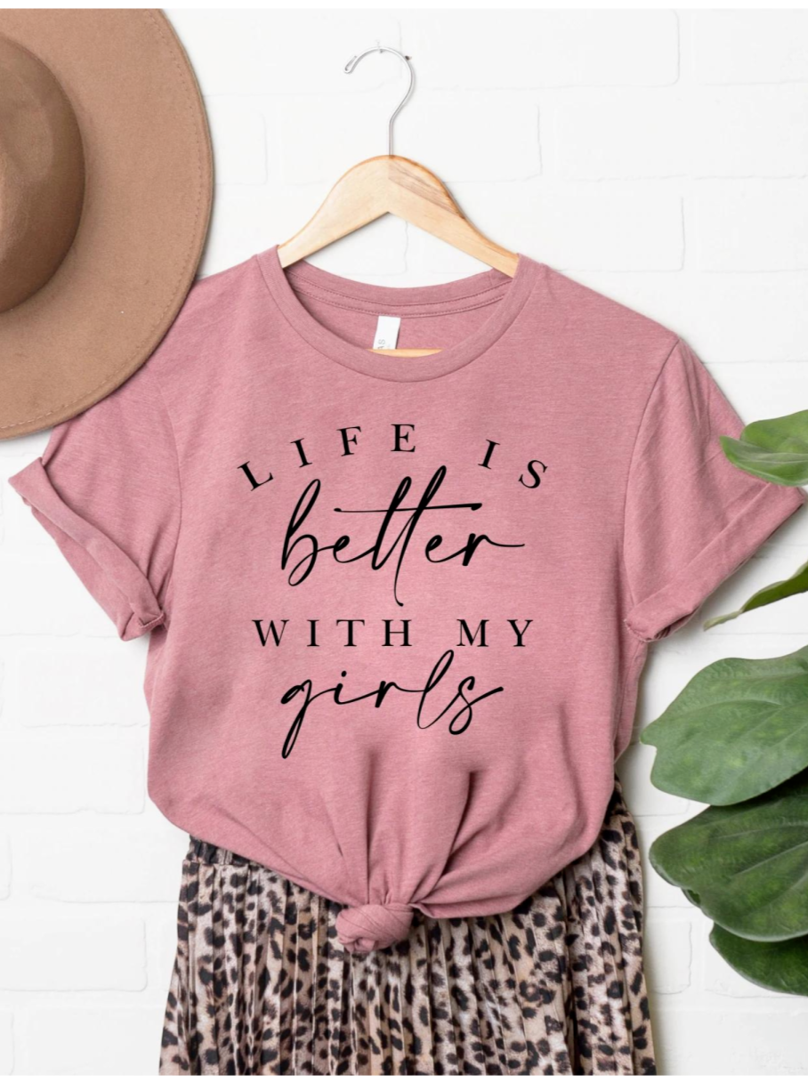 Pink t-shirt with the text "Life is better with my girls," paired with a leopard print skirt and a tan hat.