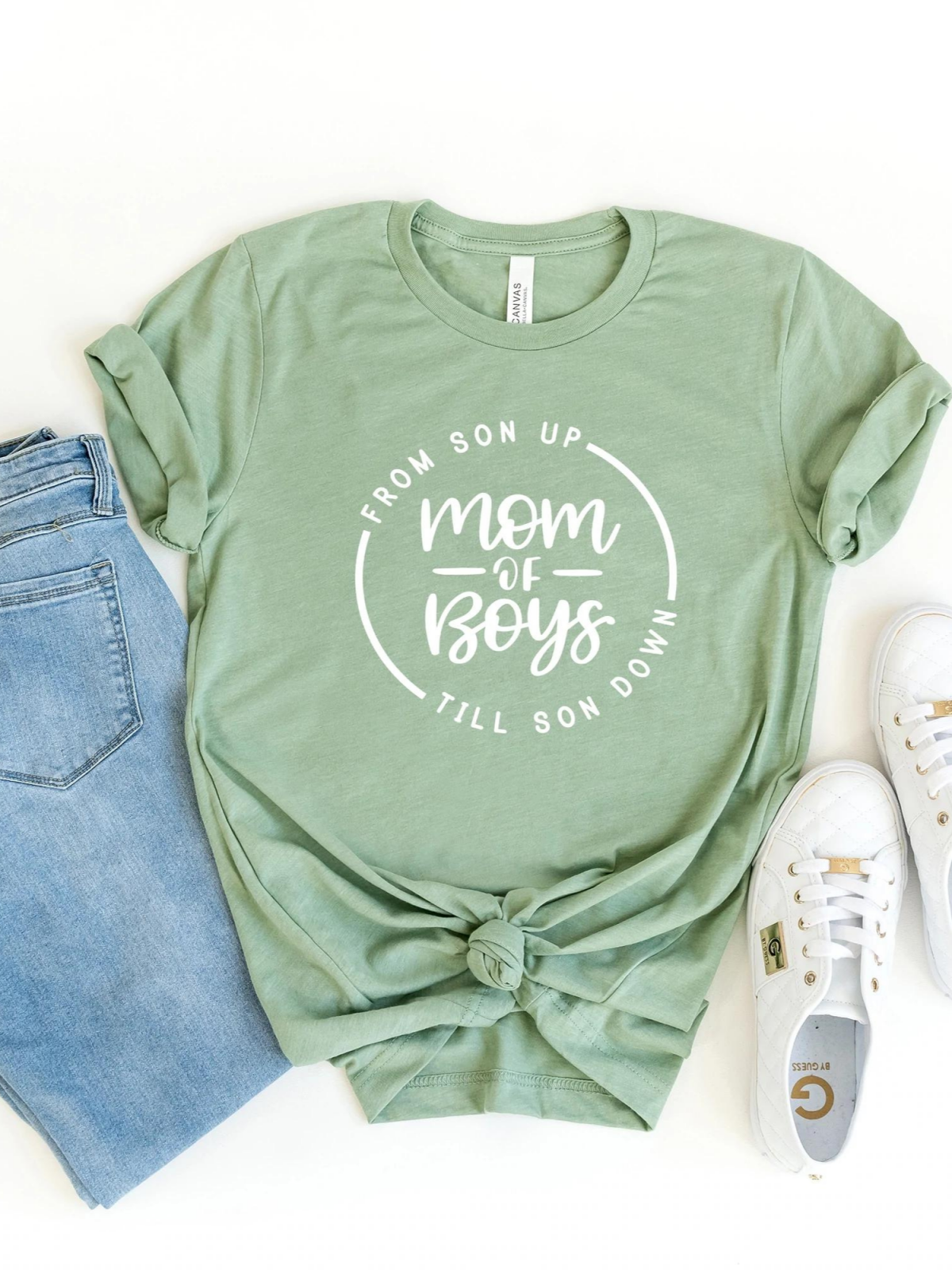 Green t-shirt with white text "From son up mom of boys till son down," paired with jeans and white sneakers.