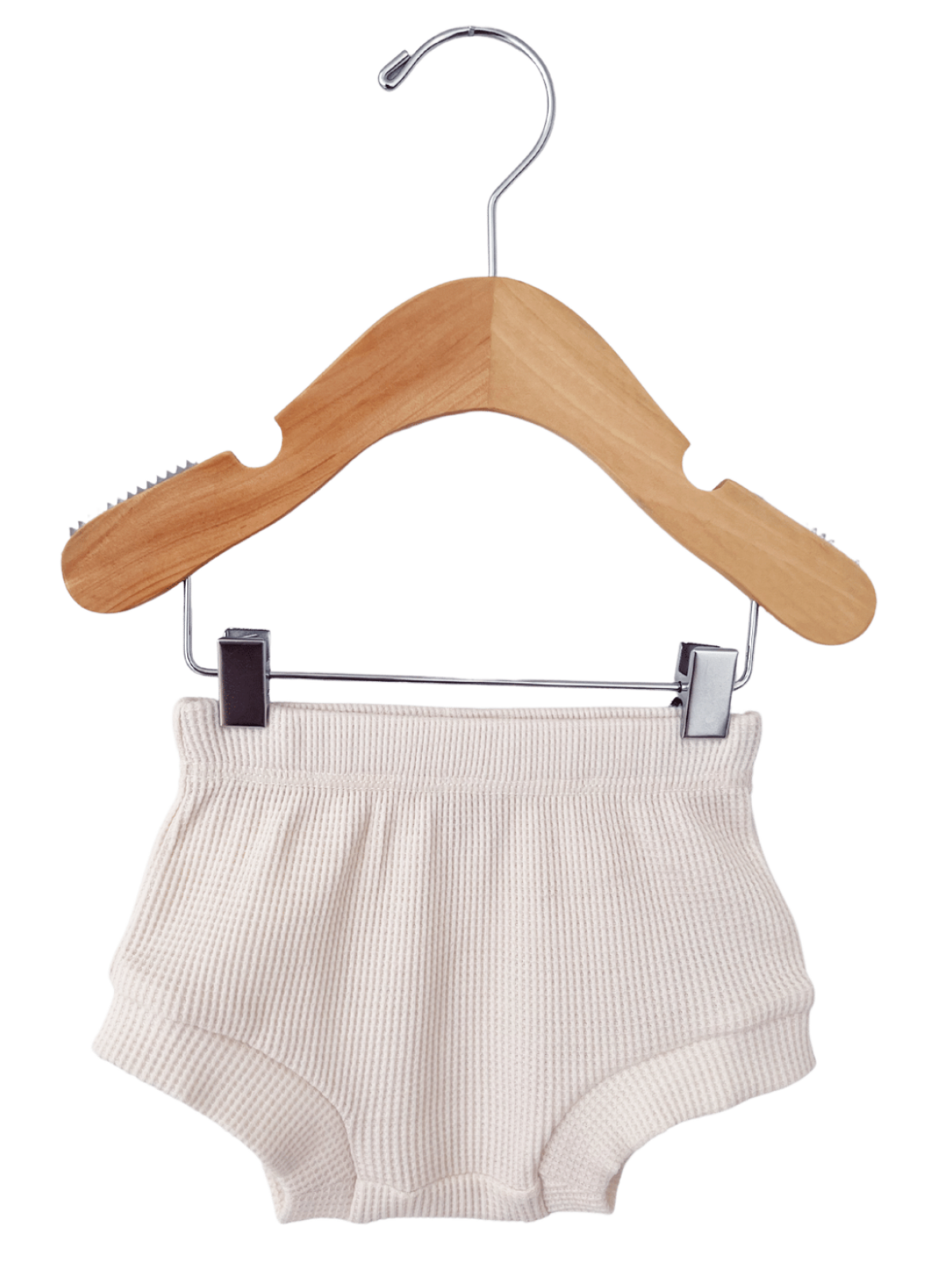 Ivory knit shorts hanging on a wooden clothes hanger against a white background.