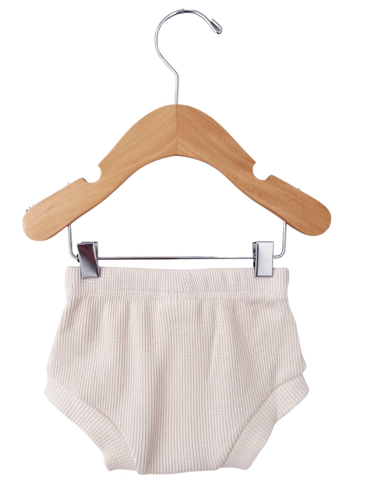 Beige infant diaper on a wooden hanger against a white background.