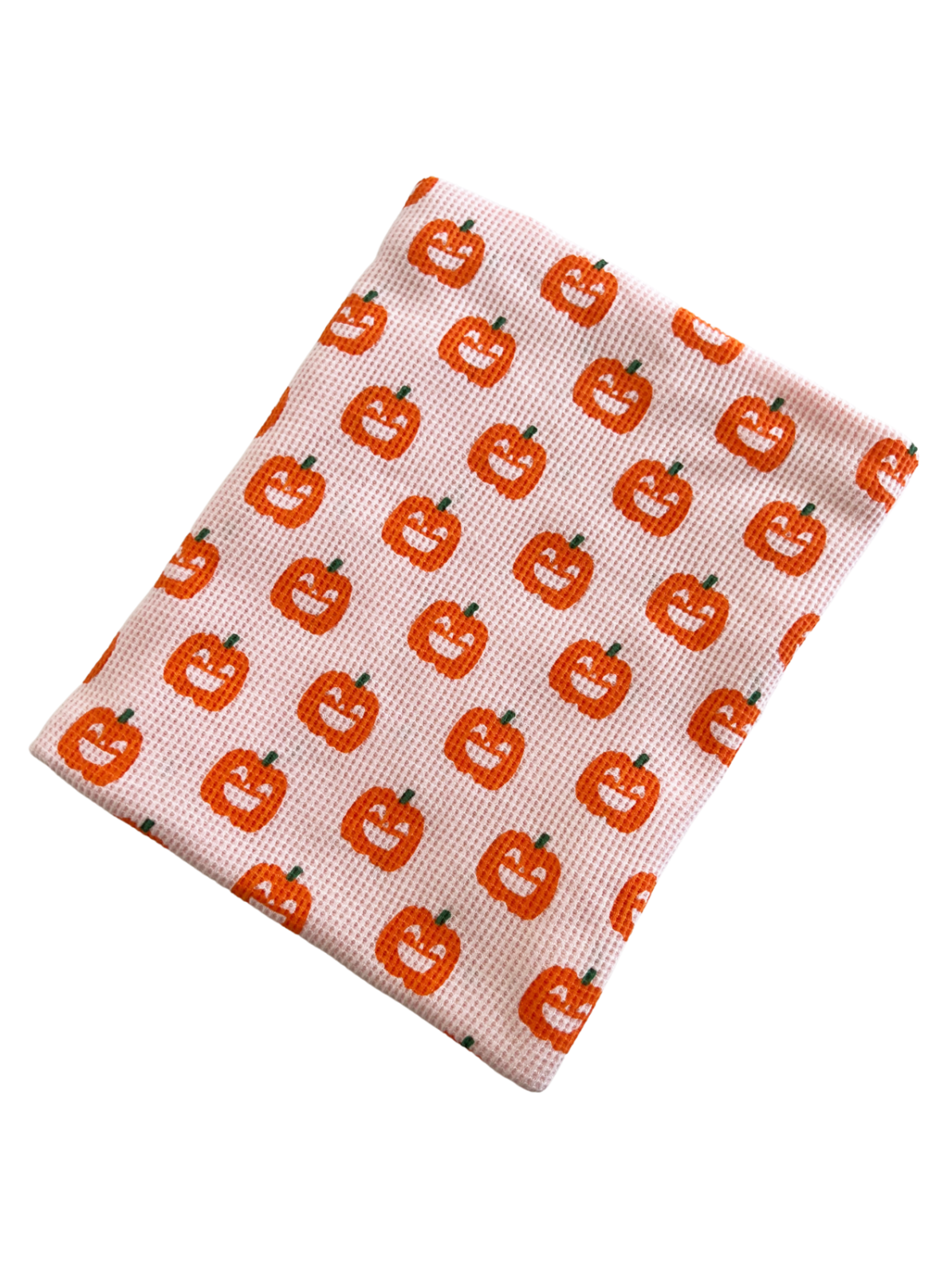 Pink cloth with a repeating pattern of smiling orange pumpkins. Ideal for Halloween decor or themed events.