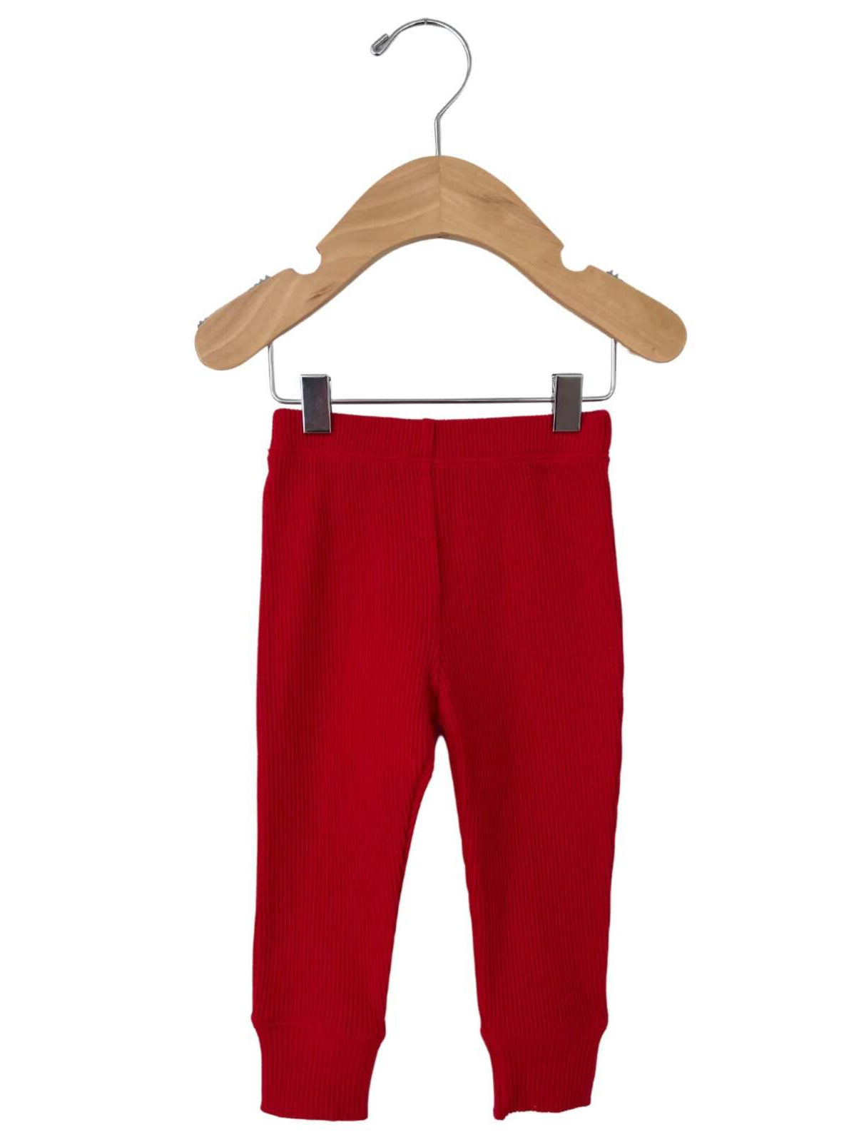 Red ribbed baby leggings hanging on a wooden hanger against a white background.