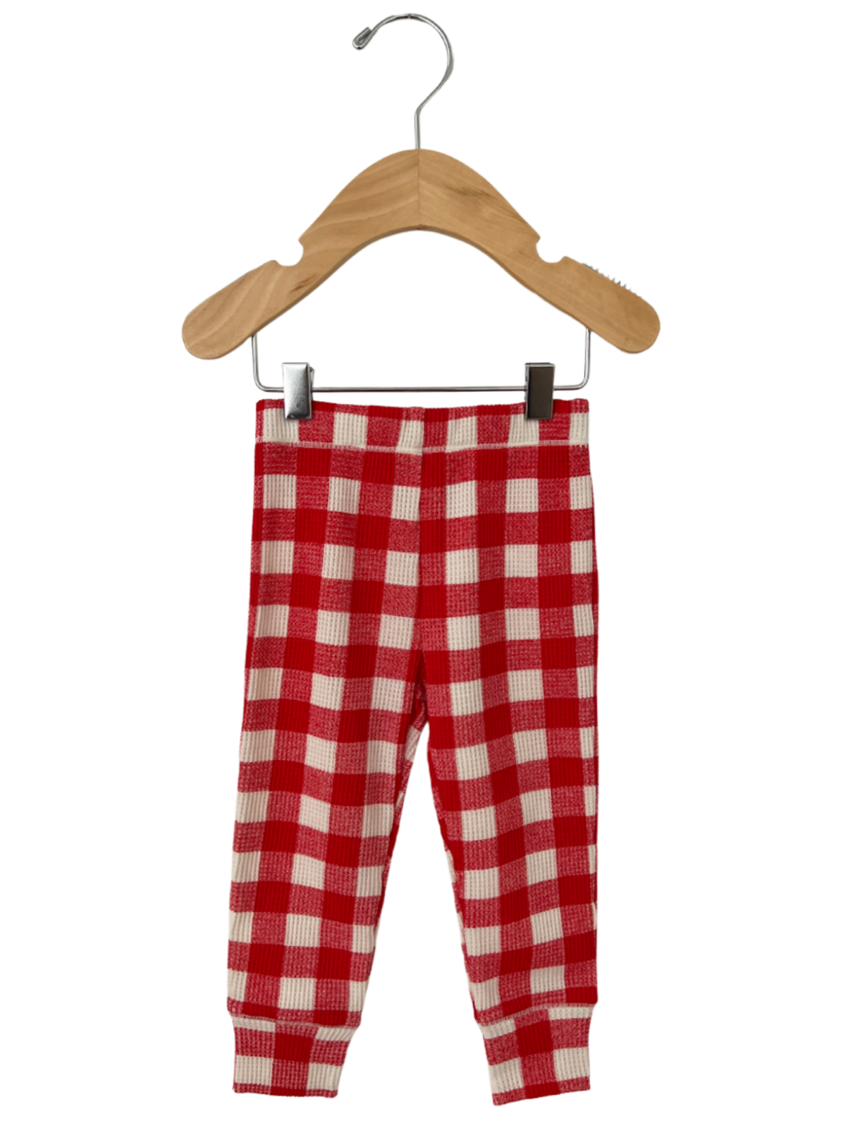 Red and white checkered toddler pants hanging on a wooden hanger.