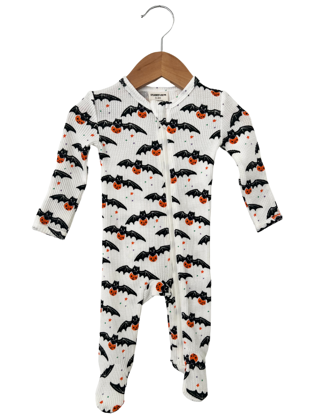 Baby onesie with bats and pumpkins design, hanging on a wooden hanger. Perfect for Halloween.