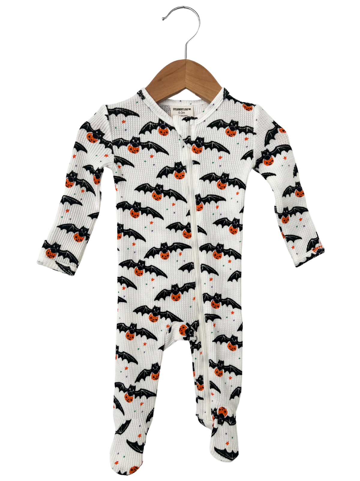 Baby onesie with bats and pumpkins design, hanging on a wooden hanger. Perfect for Halloween.