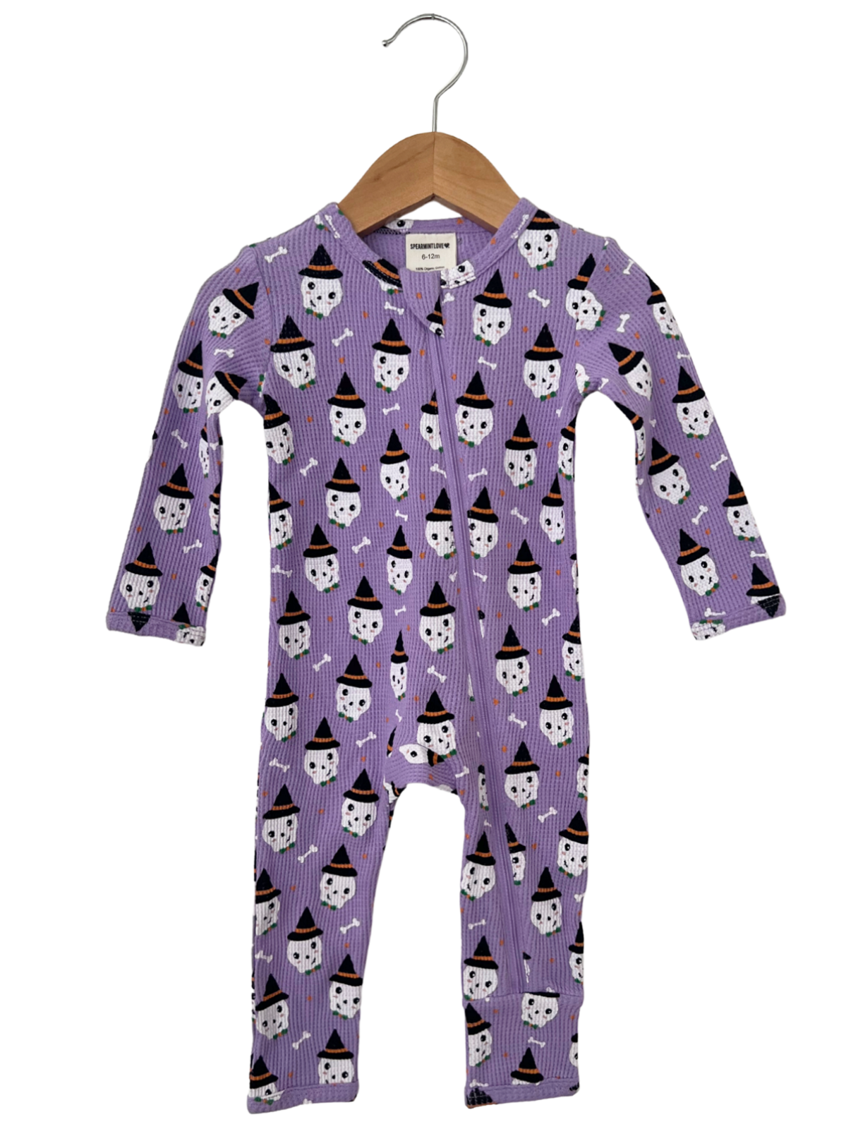 Purple baby onesie with ghost and witch hat pattern, hanging on a wooden hanger.