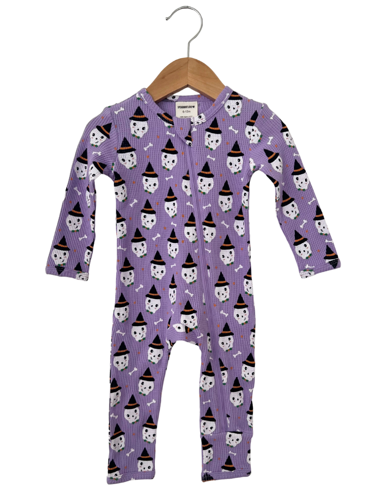 Purple baby onesie with ghost and witch hat pattern, hanging on a wooden hanger.