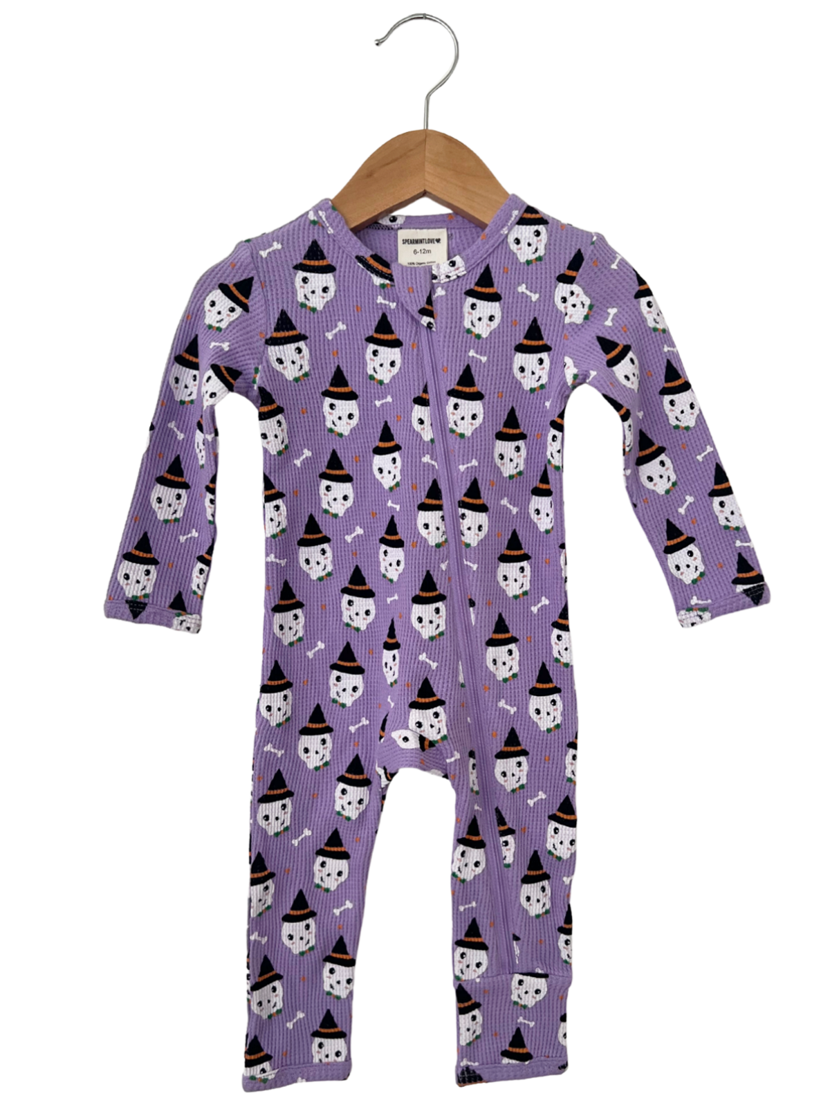 Purple baby onesie with ghost and witch hat pattern, hanging on a wooden hanger.